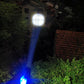 LED flashlight shining a bright blue beam from a handheld lantern-style body