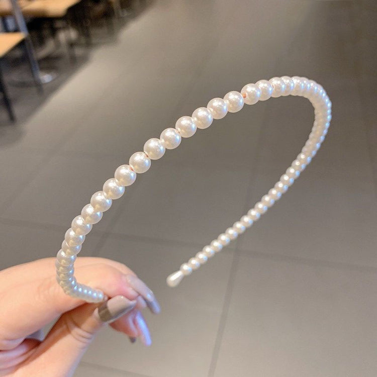 Pearl beaded headband with curved band and black inner comb, light iridescent finish