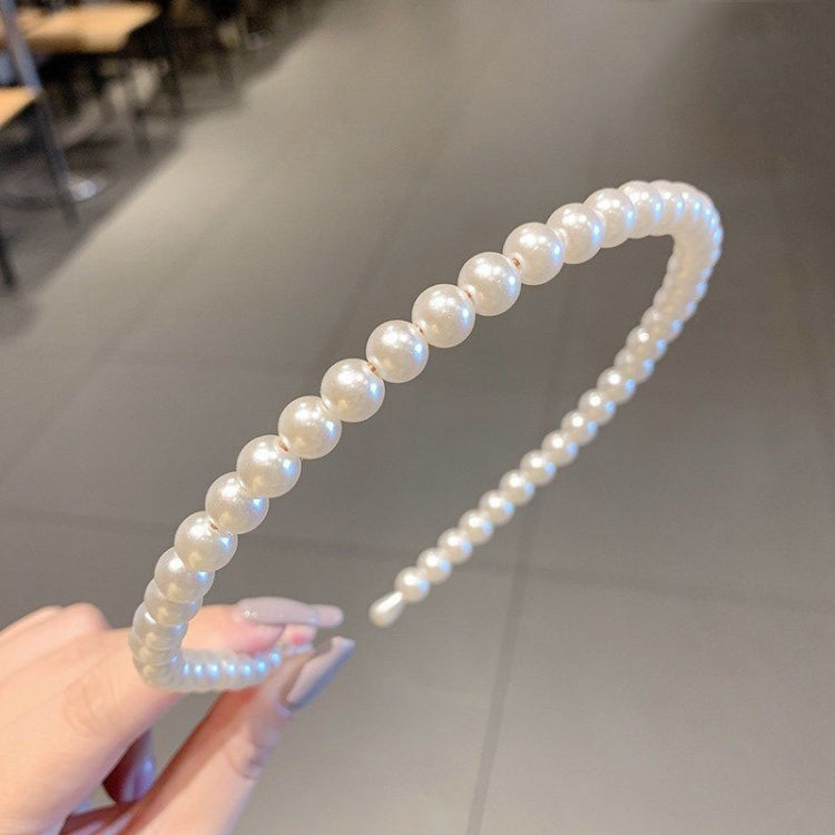 Pearl beaded headband with curved shape, black comb base, glossy iridescent pearls