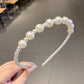 Iridescent pearl beaded headband viewed from the side, curved band and black comb
