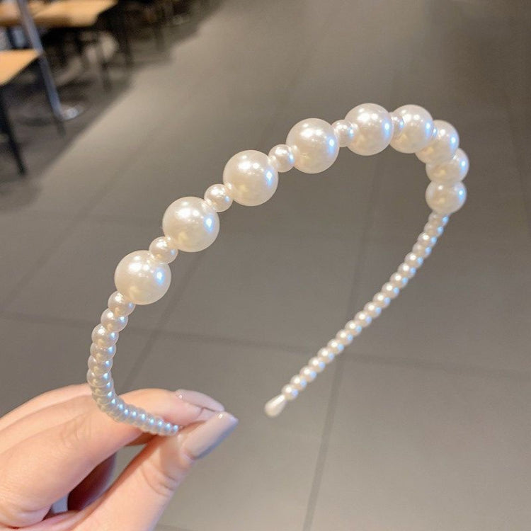 Iridescent pearl beaded headband viewed from the side, curved band and black comb