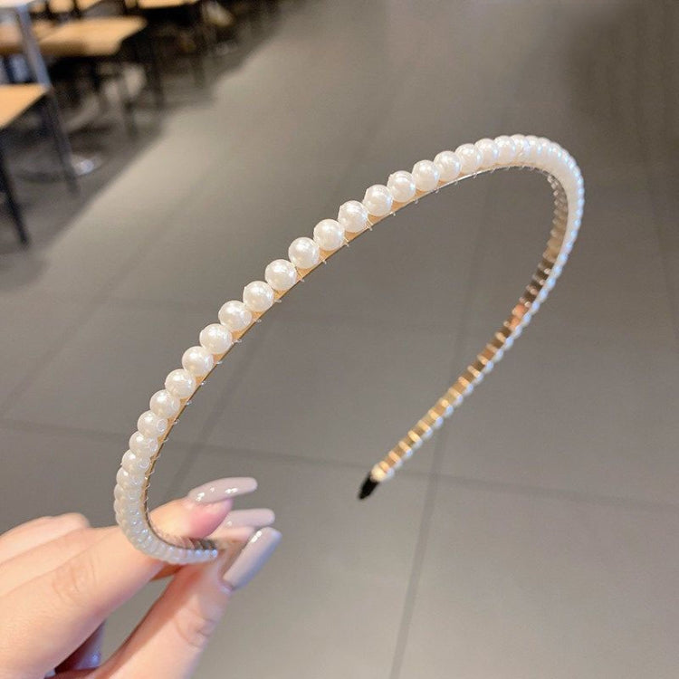 Pearl beaded headband with smooth curved band, black comb prongs visible