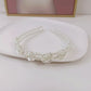 White pearl headband with layered pearl rows and centered rose appliques detail