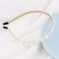 White pearl headband with double strand at the bottom and black grip ends
