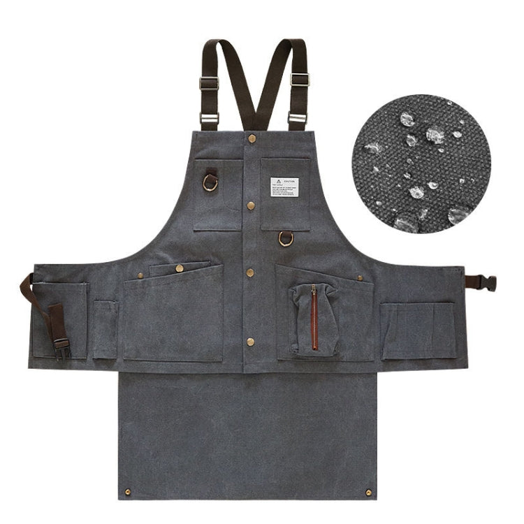 Charcoal canvas tool apron with front pockets, brass-tone buttons, and adjustable straps