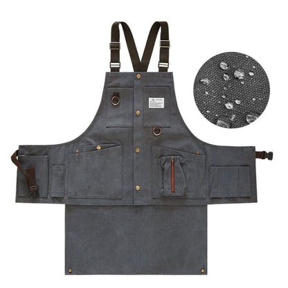 Charcoal canvas tool apron with front pockets, brass-tone buttons, and adjustable straps