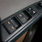 Car window switch panel with illuminated buttons on black interior door trim