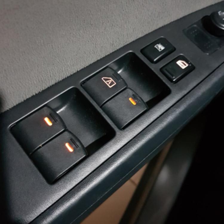 Car window switch panel with illuminated buttons on black interior door trim