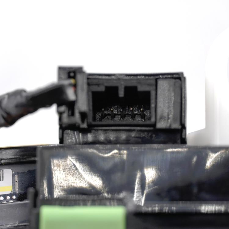 Close-up of clock spring coil connector block on black plastic housing