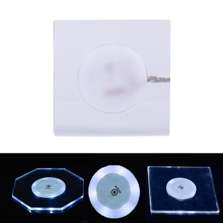 Square transparent LED acrylic coaster with white light and slim crystal base, on/off switch visible.
