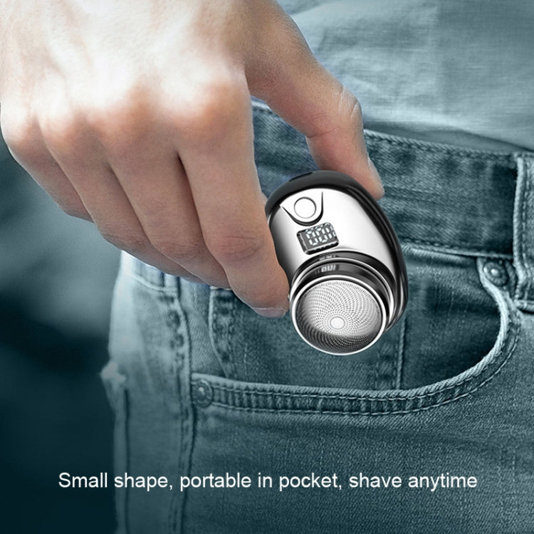 Hand holding compact mini electric shaver with round foil head and LCD panel