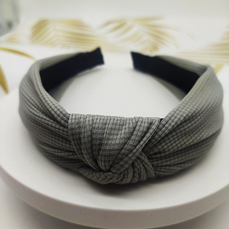 Wide knotted headband in light gray knit fabric with dark inner backing.