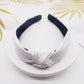 Pressed fabric headband, white with dark navy knotted center and wide band