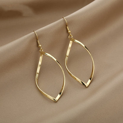 Gold twisted hoop earrings with faceted teardrop shape and hook backs