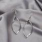 Silver twisted hoop earrings with faceted teardrop shape and hook backs