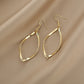 Gold twisted hoop earrings with faceted teardrop profile and fishhook closures