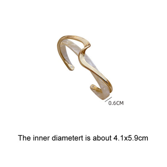 Gold-tone cuff bracelet with white shell-like inlay, open design