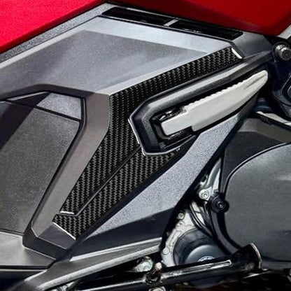 Rear footrest lower protector, black carbon-fiber style trim with raised channels