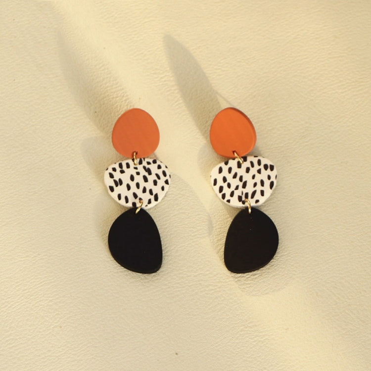 Dangle earrings with orange top discs, leopard print oval, and black teardrop bottoms