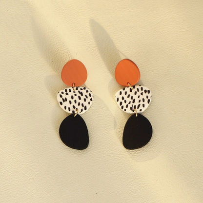 Dangle earrings with orange top discs, leopard print oval, and black teardrop bottoms