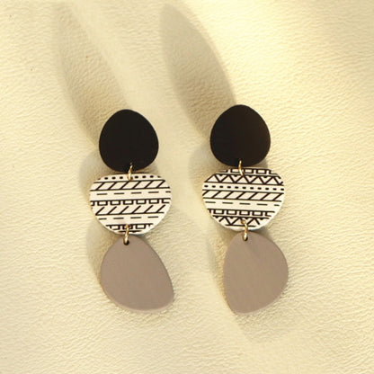 Long acrylic drop earrings with black top, white geometric middle, gray oval dangles