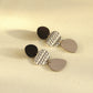Long acrylic drop earrings, black discs with patterned white oval and gray dangle