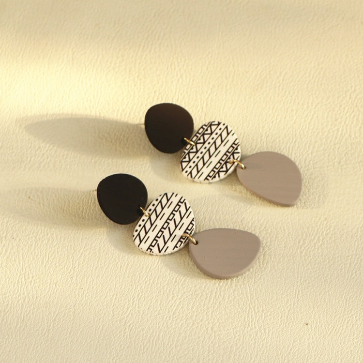 Long acrylic drop earrings, black discs with patterned white oval and gray dangle