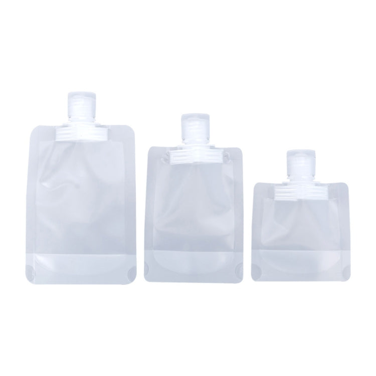 Set of clear refillable squeeze pouches with flip-top caps in different sizes