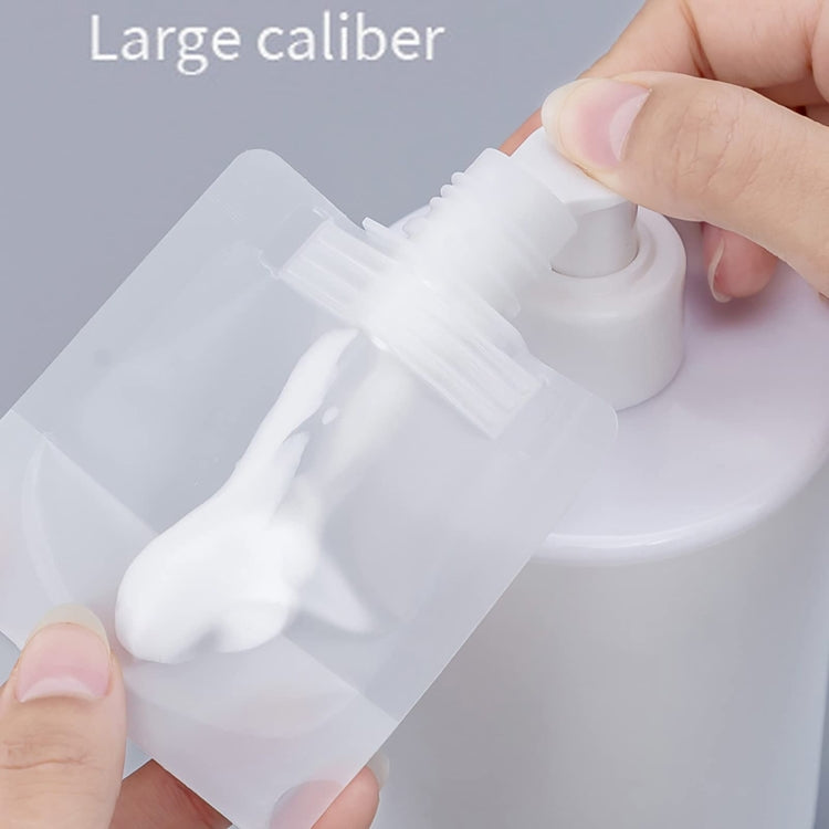 Hand squeezing a clear refillable squeeze pouch with large-cap spout
