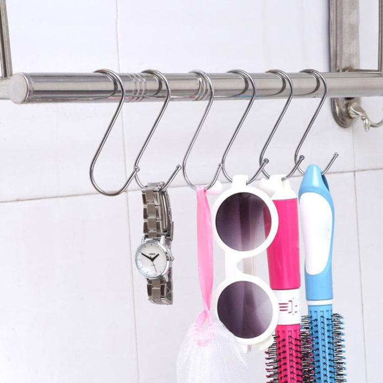 Stainless steel S-hooks on a bar holding kitchen accessories like cups and a watch