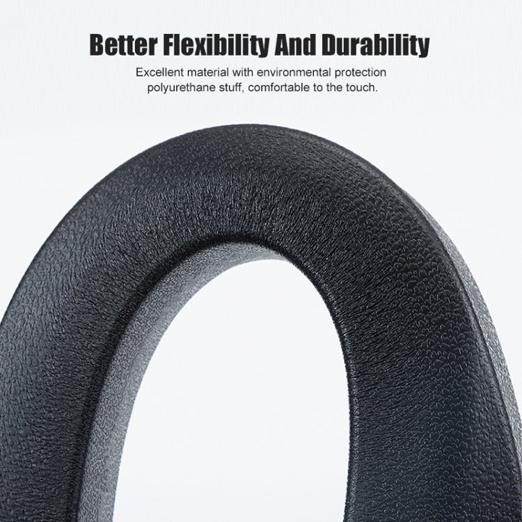 Black flexible car seat gap filler plug, textured surface close-up.