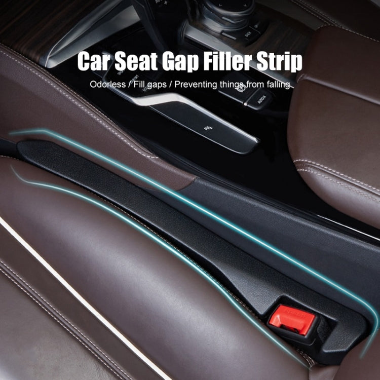 Blue car seat gap filler strip installed along console gap with red latch.