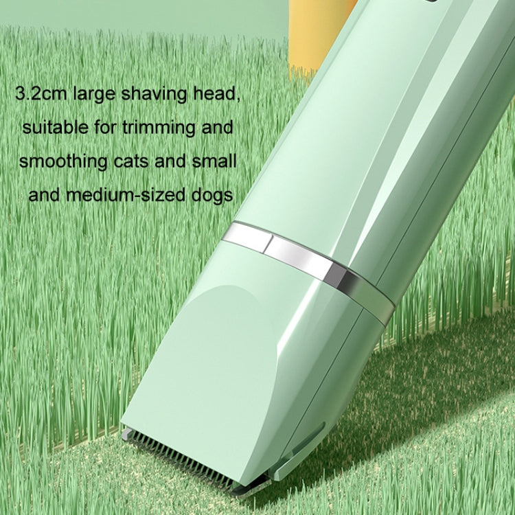 Green electric pet clipper with large shaving head on grass background