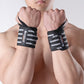 Pair of black weightlifting wrist wraps with white striped bands on wrists
