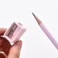 Handheld mini pencil sharpener with pink body and exposed metal cutting blade