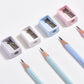 Mini pencil sharpeners with blue, pink, and white bodies, plus colored pencils