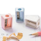 Three mini pencil sharpeners with pink, blue, and white plastic housings and blades