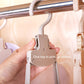 Plastic folding hanger with quick-release button, held in a hand over a bar