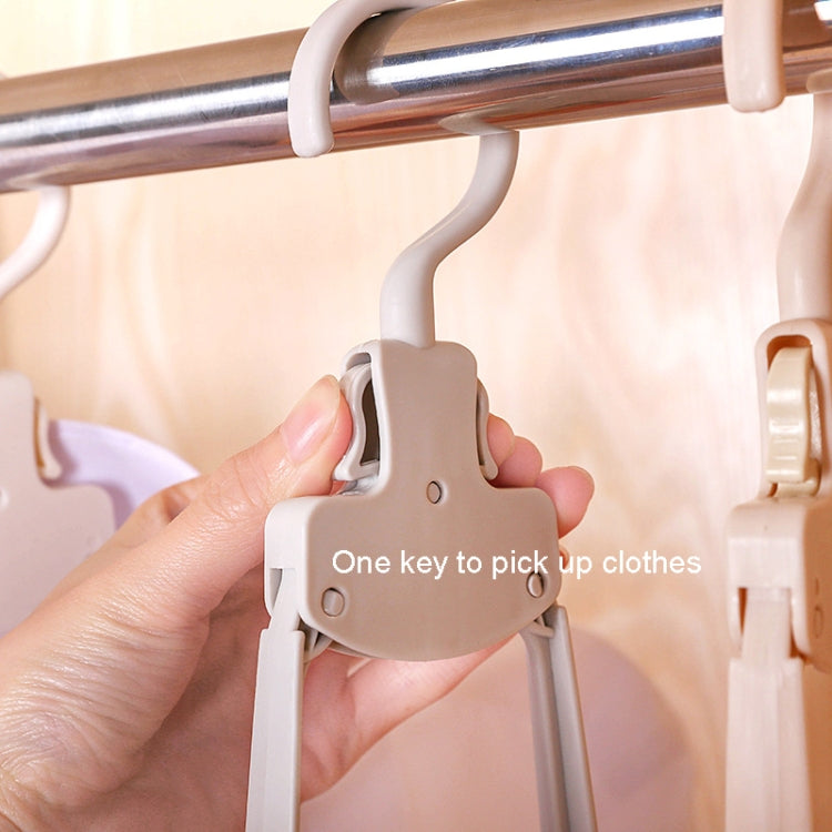 Plastic folding hanger with quick-release button, held in a hand over a bar