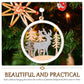 Round wooden Christmas pendant with deer and evergreen trees, hanging on a Christmas tree