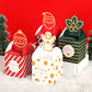 Set of Christmas candy gift boxes in red, green, and gold with decorative ornament toppers