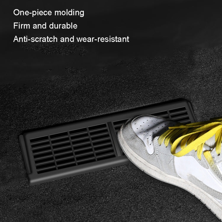 Under-seat vent cover with black rectangular grille, shown under a sneaker