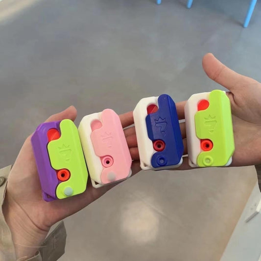 Hand holding colorful gravity decompress fidget pieces: green, pink, blue, and purple