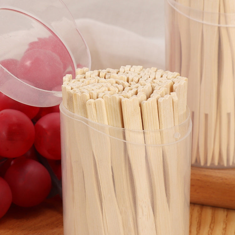 Stacked view of bamboo two-tine dessert forks in clear plastic containers