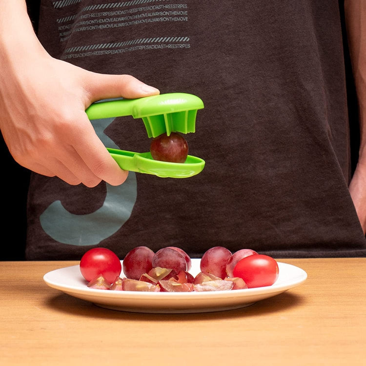 Green fruit slicer tool cutting fruit on a plate