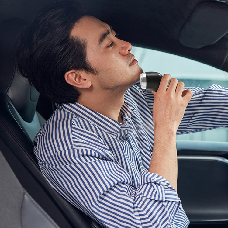 Handheld rechargeable electric shaver in use on a person’s face
