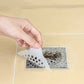 Hand lifting used disposable non-woven drain filter sticker from floor drain