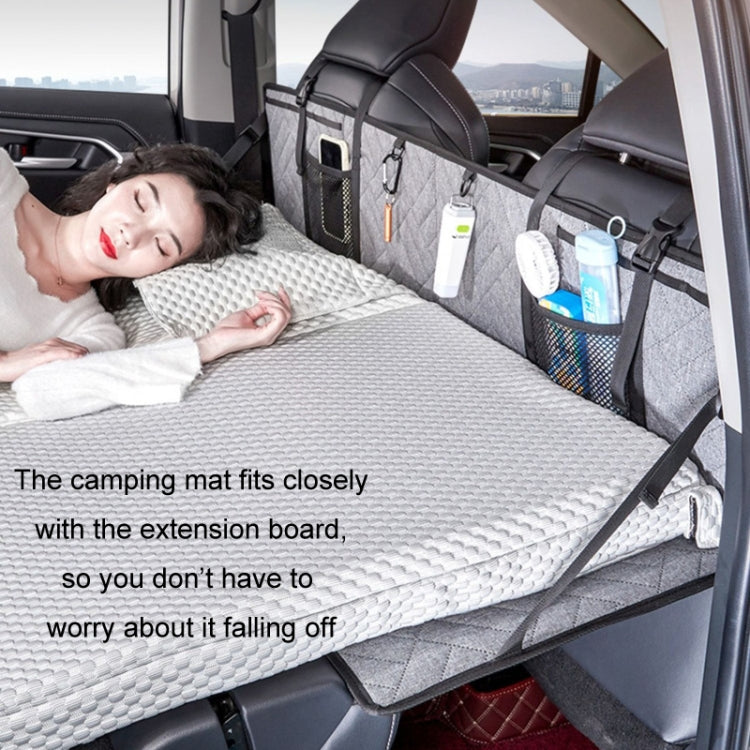 Car camping bed extension board with quilted cover and storage organizers, person lying