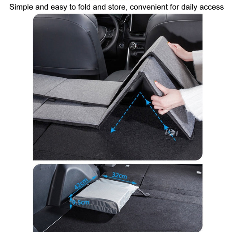 Hand folding a gray car camping bed extension board for compact storage