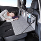 Car camping bed extension board with quilted gray mattress and front storage organizer, person resting